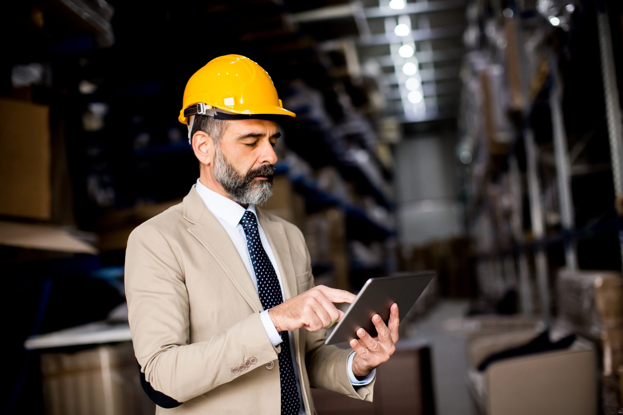 Portrait of middle-aged businessman with digital tablet in factory